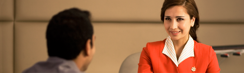 Royal Jordanian staff in uniform happily helping out a customer